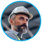 A close-up of a focused construction manager wearing a hard hat, emphasizing leadership in site safety and project oversight.