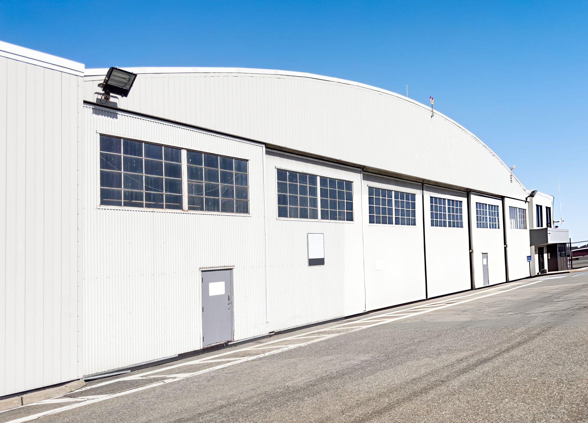 Butler hydraulic or bifold aircraft hangar door system opening upward on a commercial aviation metal building