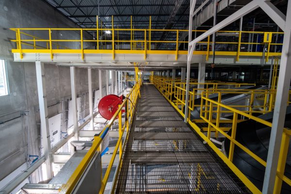 Butler catwalk structural connection detail showing hanger rod mounting bracket and load distribution anchoring to primary building column