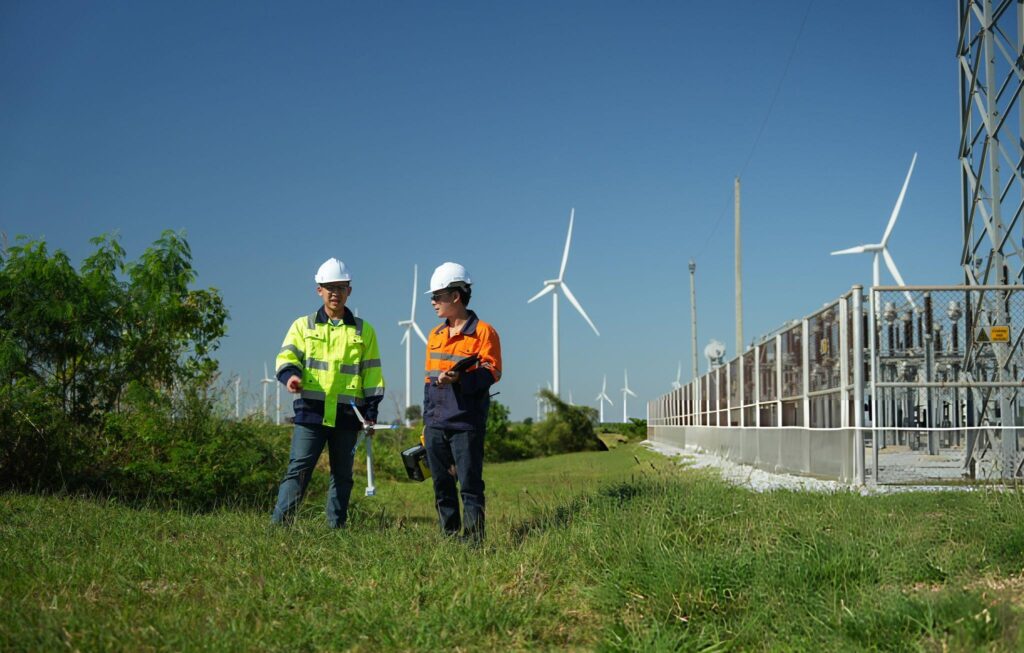 Butler Engineers are checking the operation of a large wind turbine that is working to generate electricity in a wind farm