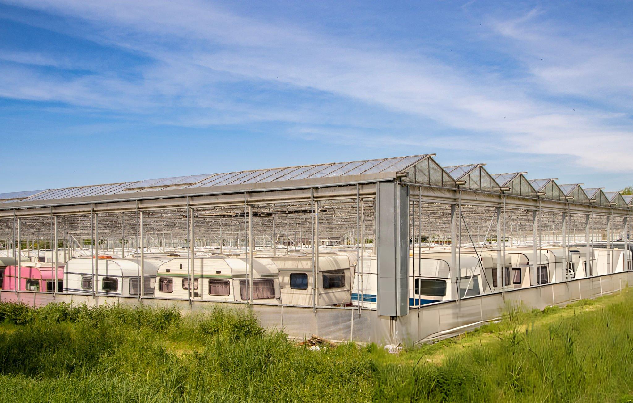 Butler RV stored inside greenhouse structure